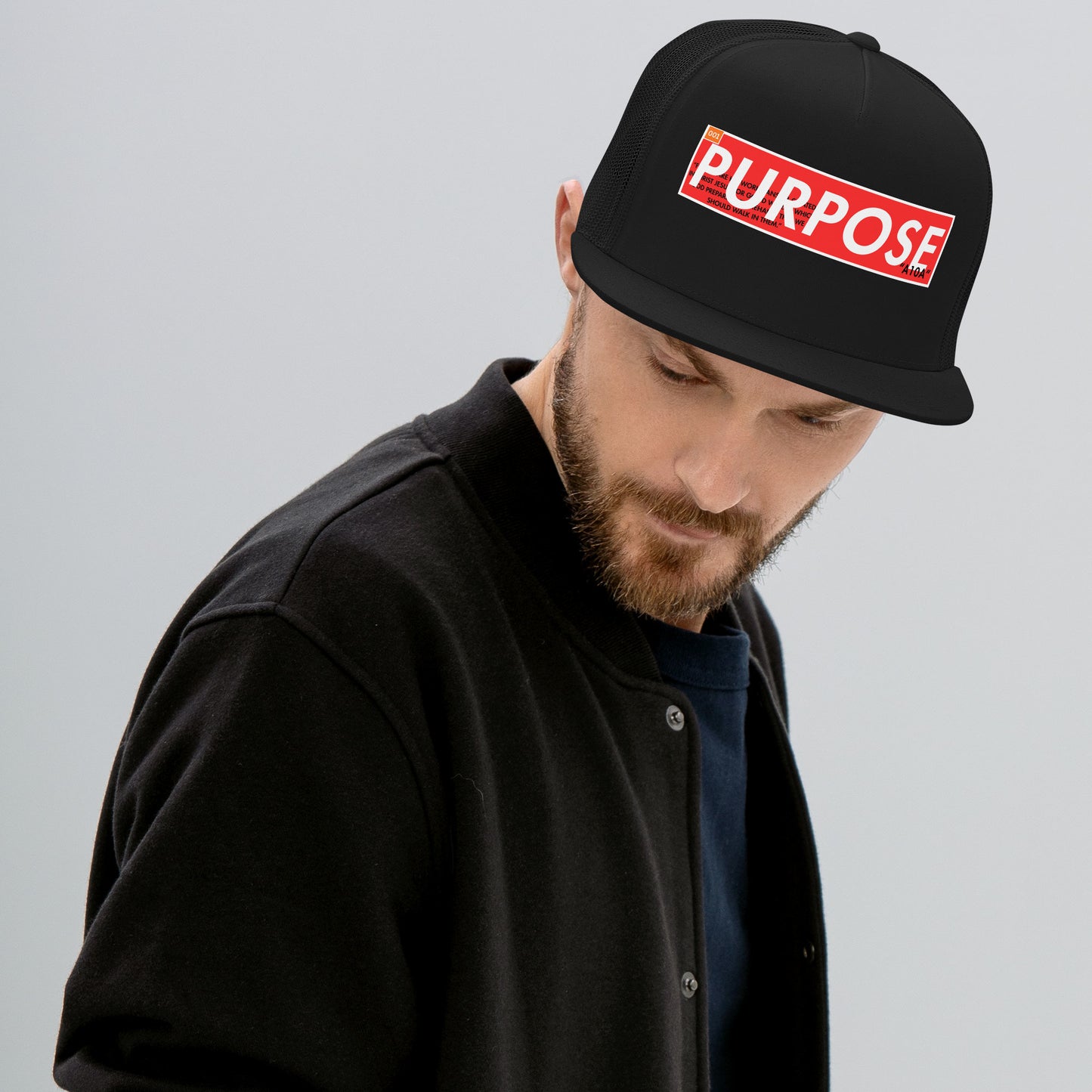 Model wearing the Premium Faithwear Unisex Trucker Hat with the 'Purpose' design, embodying faith and style. This hat reflects a commitment to beliefs and quality from a veteran-owned small business. Christian, faith, believe, premium, veteran owned, small business.