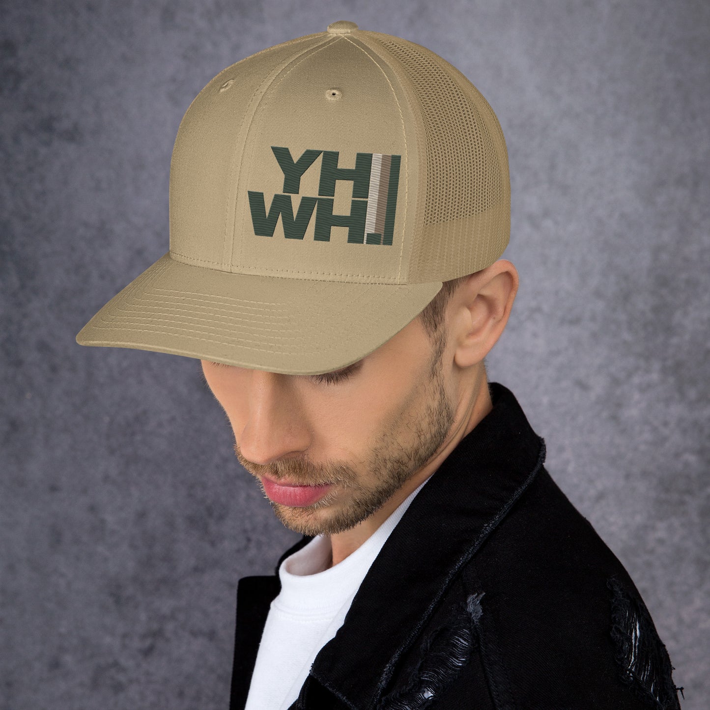 Model wearing YHWH Collection Unisex Trucker Cap in beige, showcasing its trendy design. This cap represents faith and style from a veteran owned small business, perfect for all supporters.